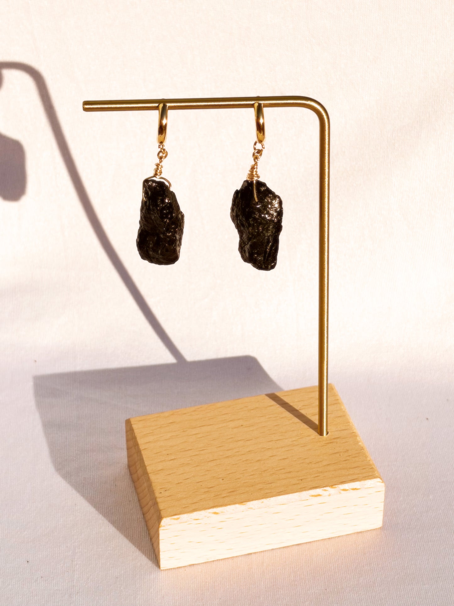 Gold Stainless Steel earrings with Black Tourmaline stones on a white background.