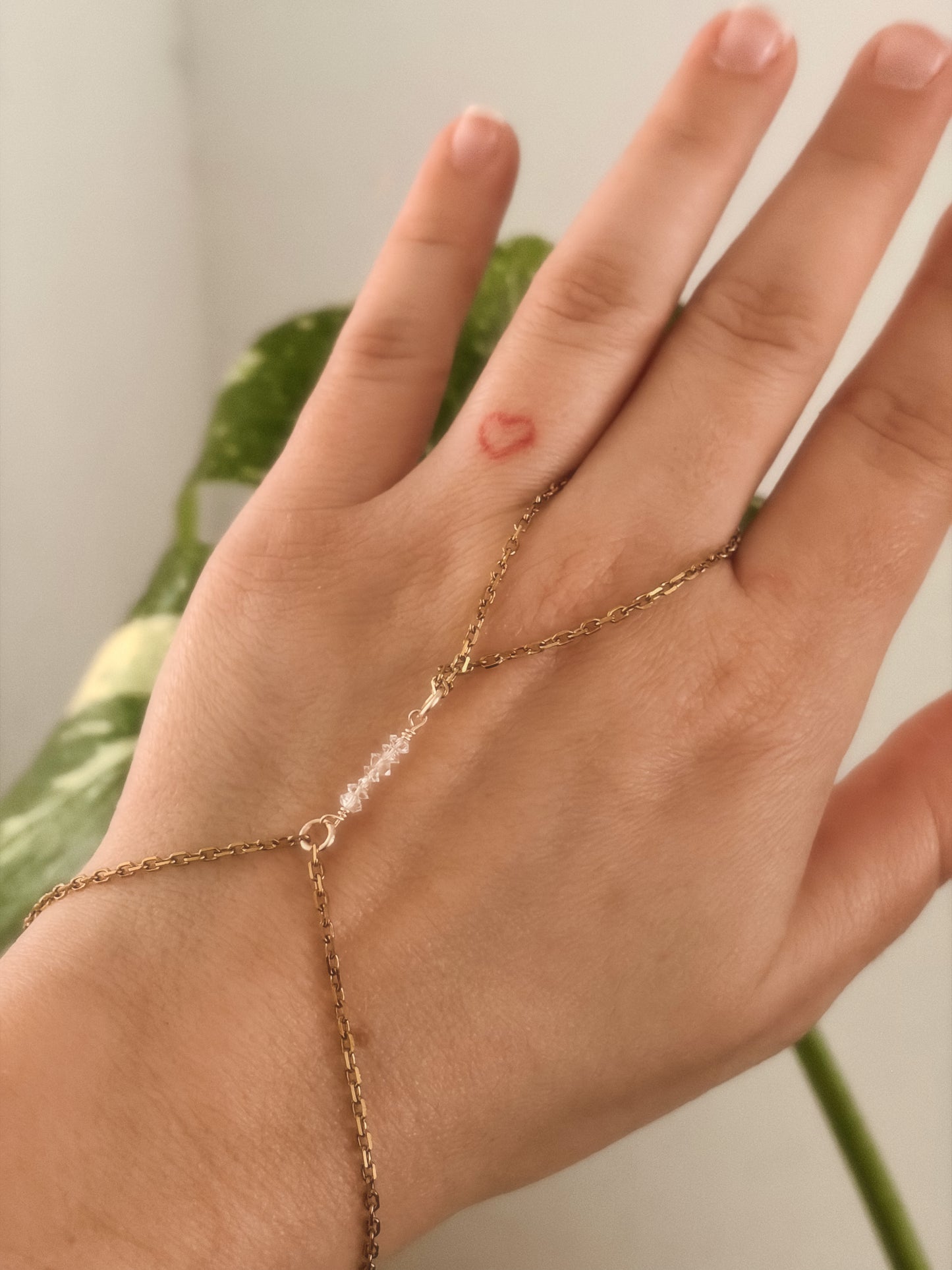 Gold Stainless Steel tarnish resistant handchain with Herkimer Diamond crystal beads on a person's hand.