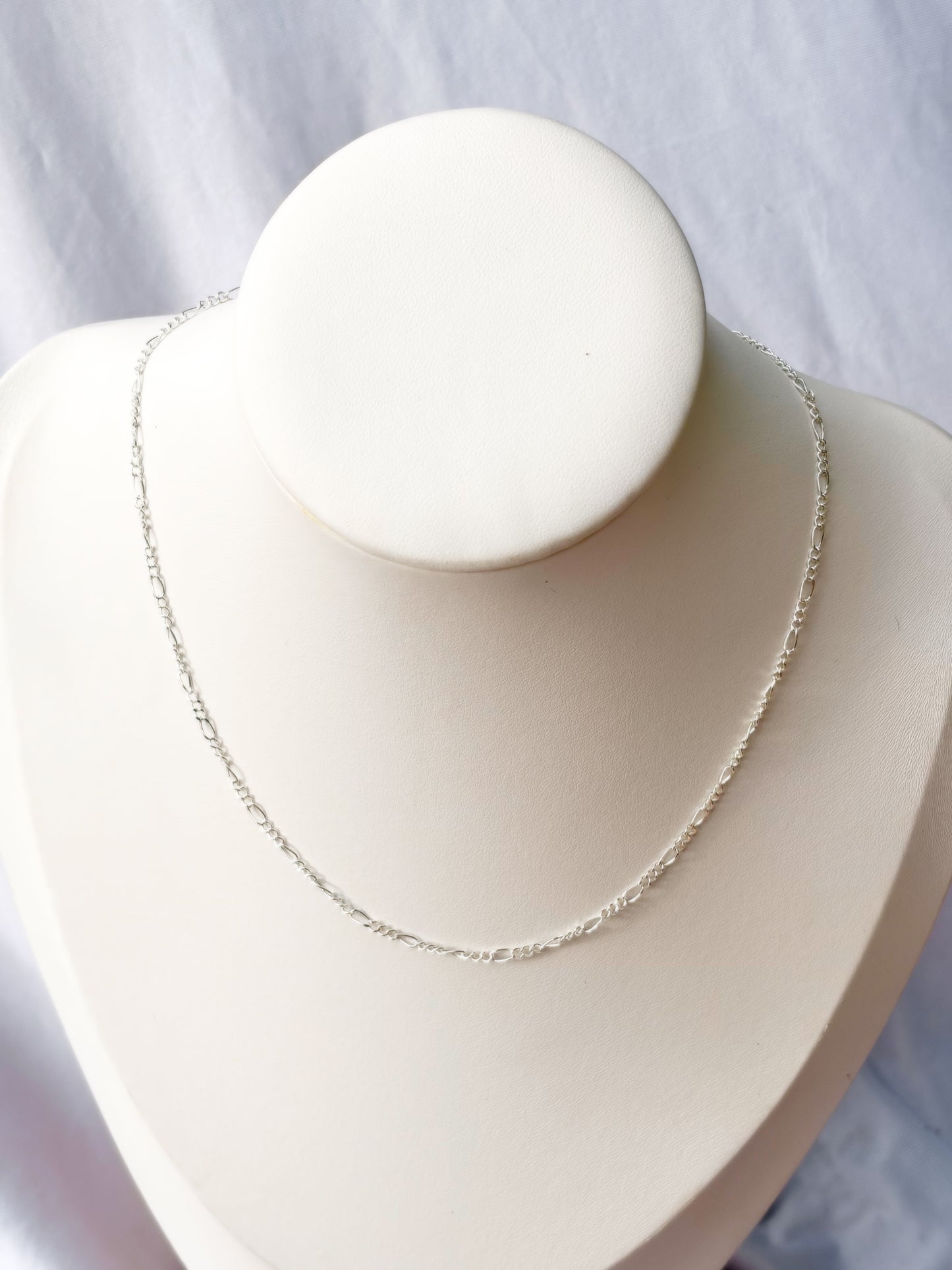 Figaro Stainless Steel Silver chain Necklace on a white mannequin bust and background.