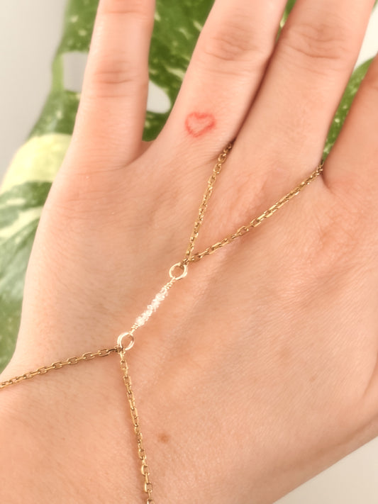 Gold Stainless Steel tarnish resistant handchain with Herkimer Diamond crystal beads on a person's hand.