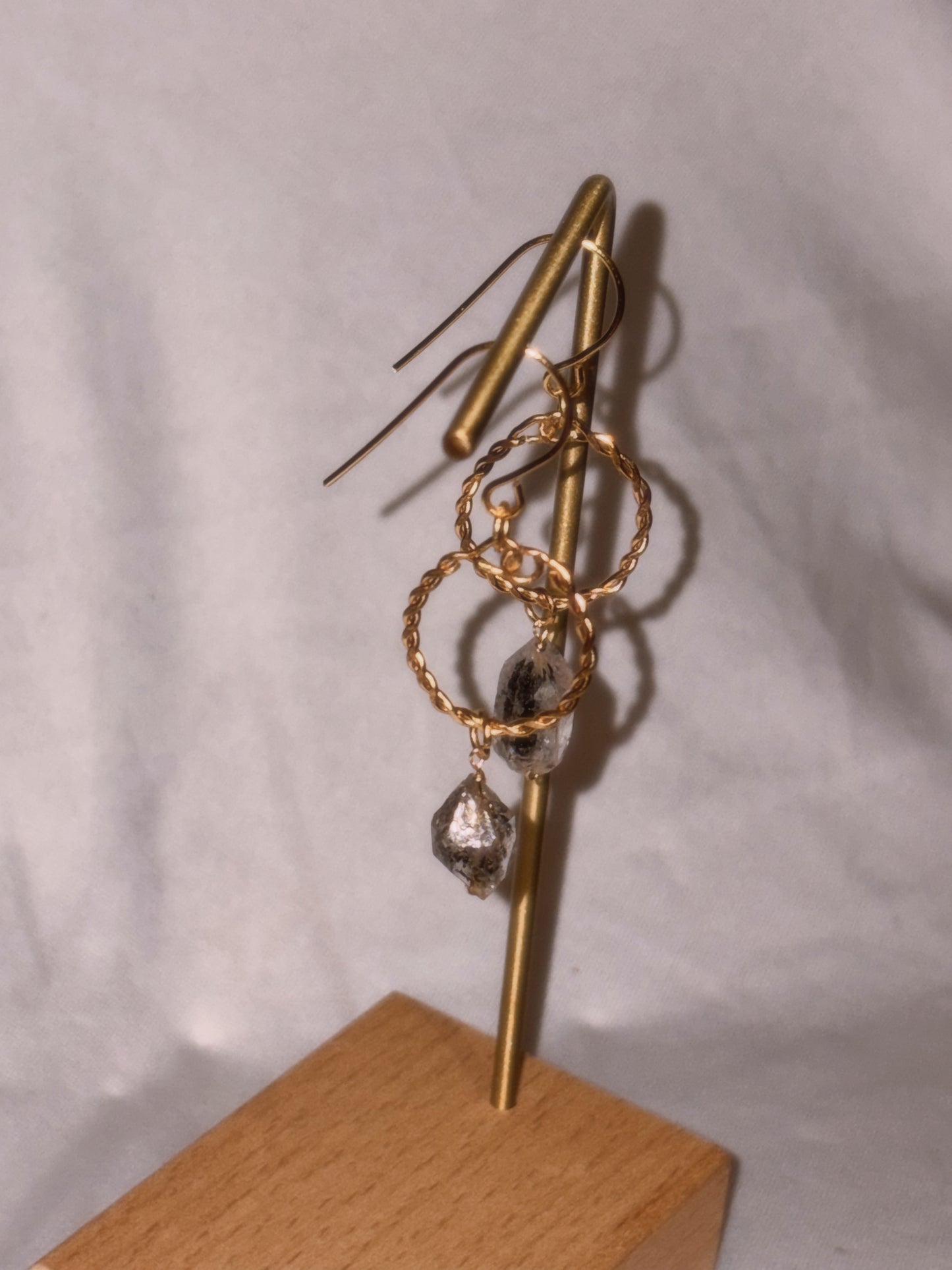 Gold hoop earrings with Herkimer Crystal  drops on a gold stand against a white background.