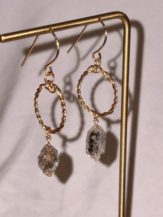 Gold hoop earrings with Herkimer Crystal  drops on a gold stand against a white background