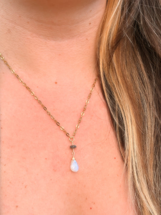 Stainless Steel Gold Necklace with a Labradorite and Rainbow Moonstone pendant on a person's neck.