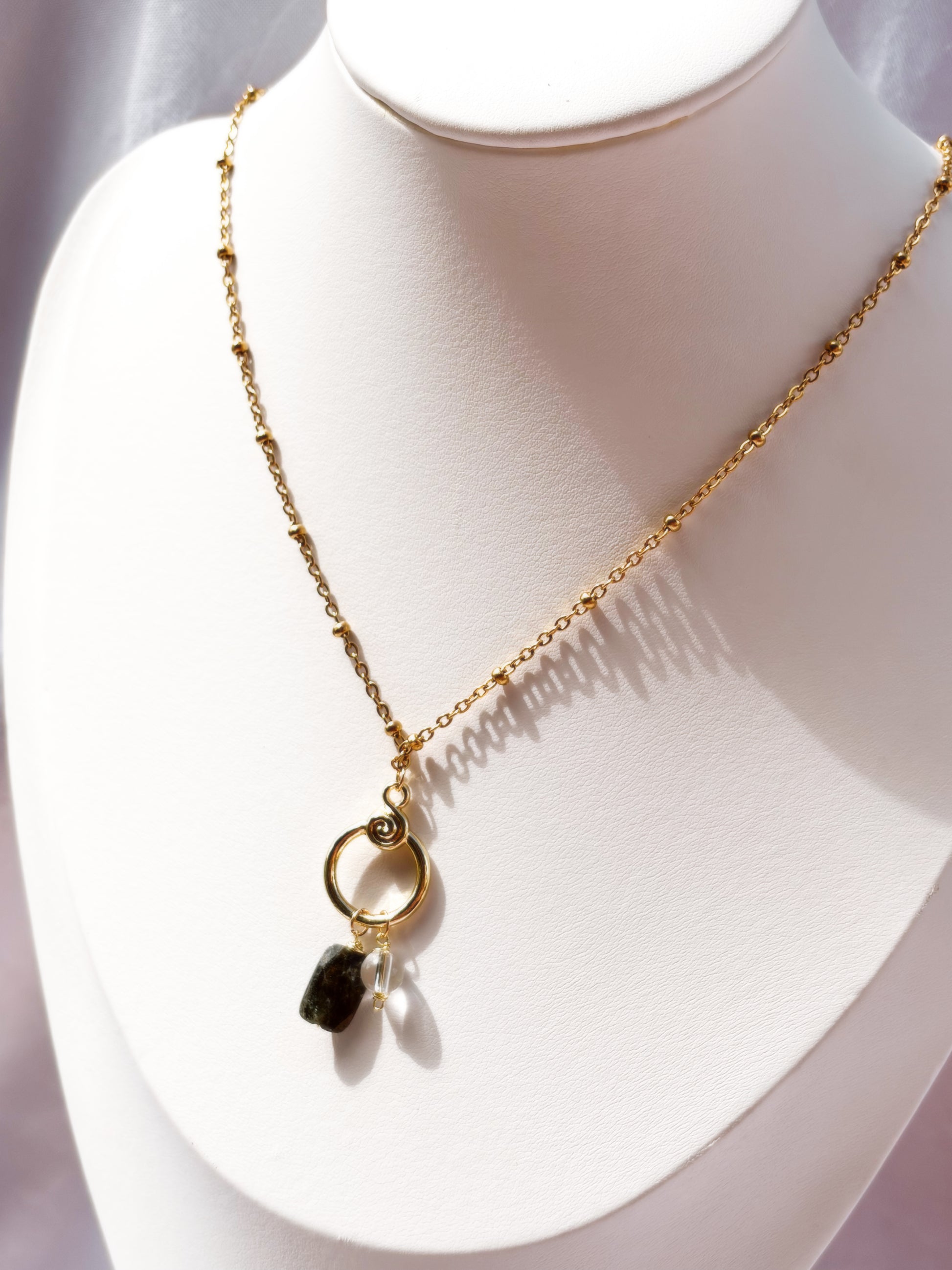 Gold Stainless Steel necklace with Blue Kyanite and Clear Quartz as a pendant on a white mannequin