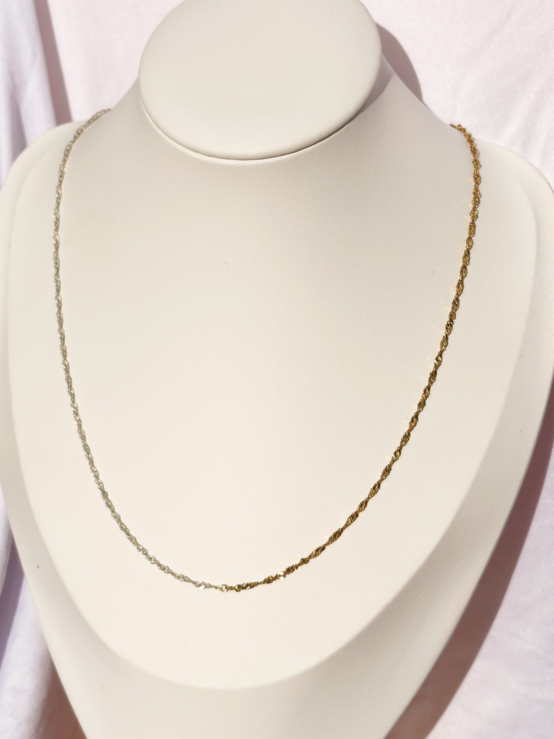 Figaro Gold and Silver Necklace on a bust on a white background.