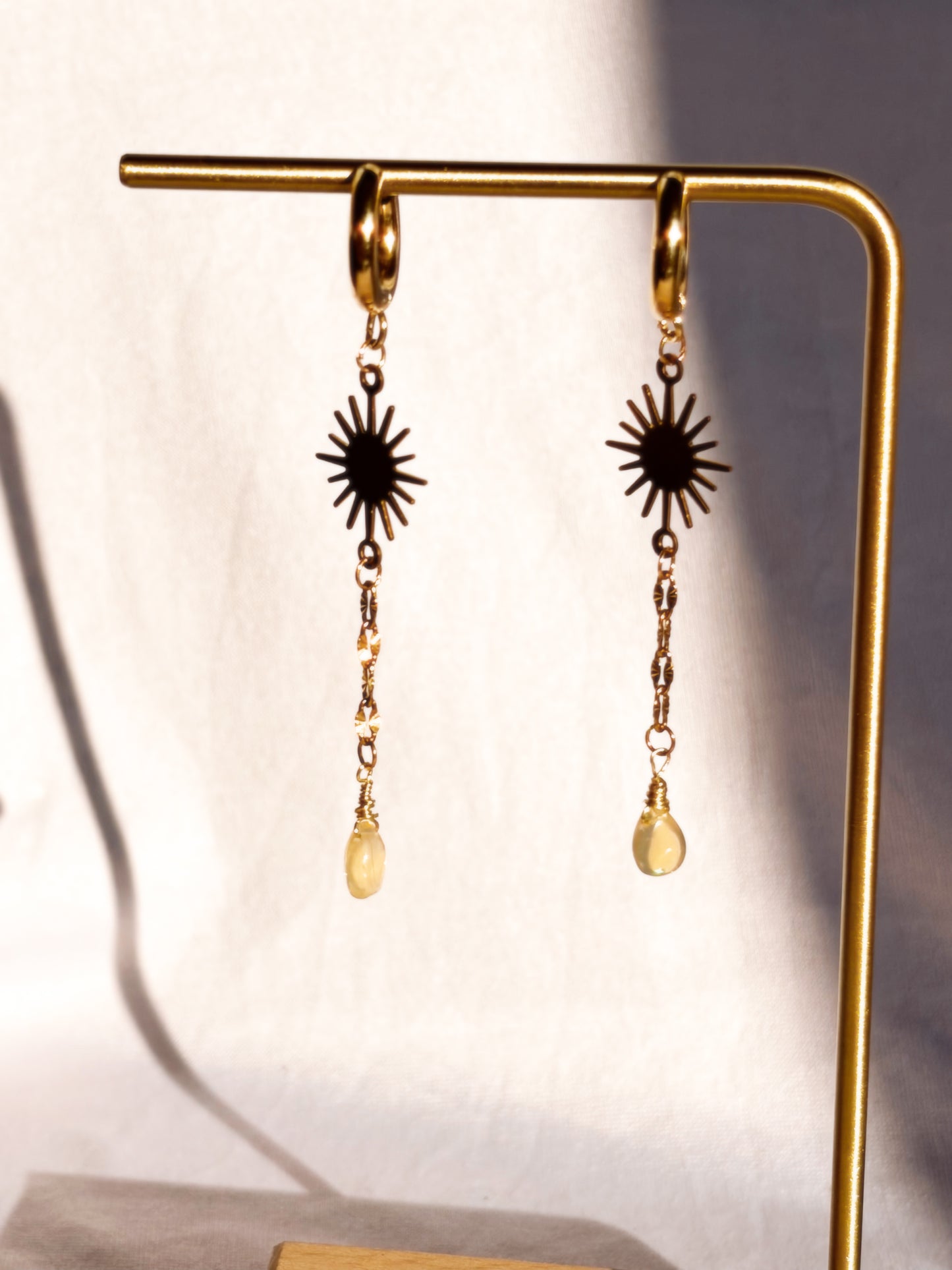 Gold Stainless Steel Ethiopian Opal earrings with Sun charms on a white background