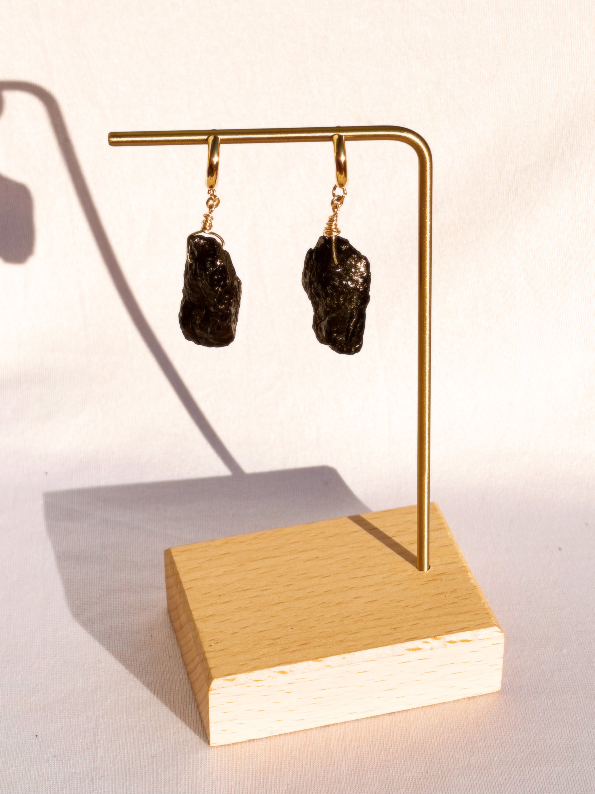 Gold Stainless Steel earrings with Black Tourmaline stones on a white background.