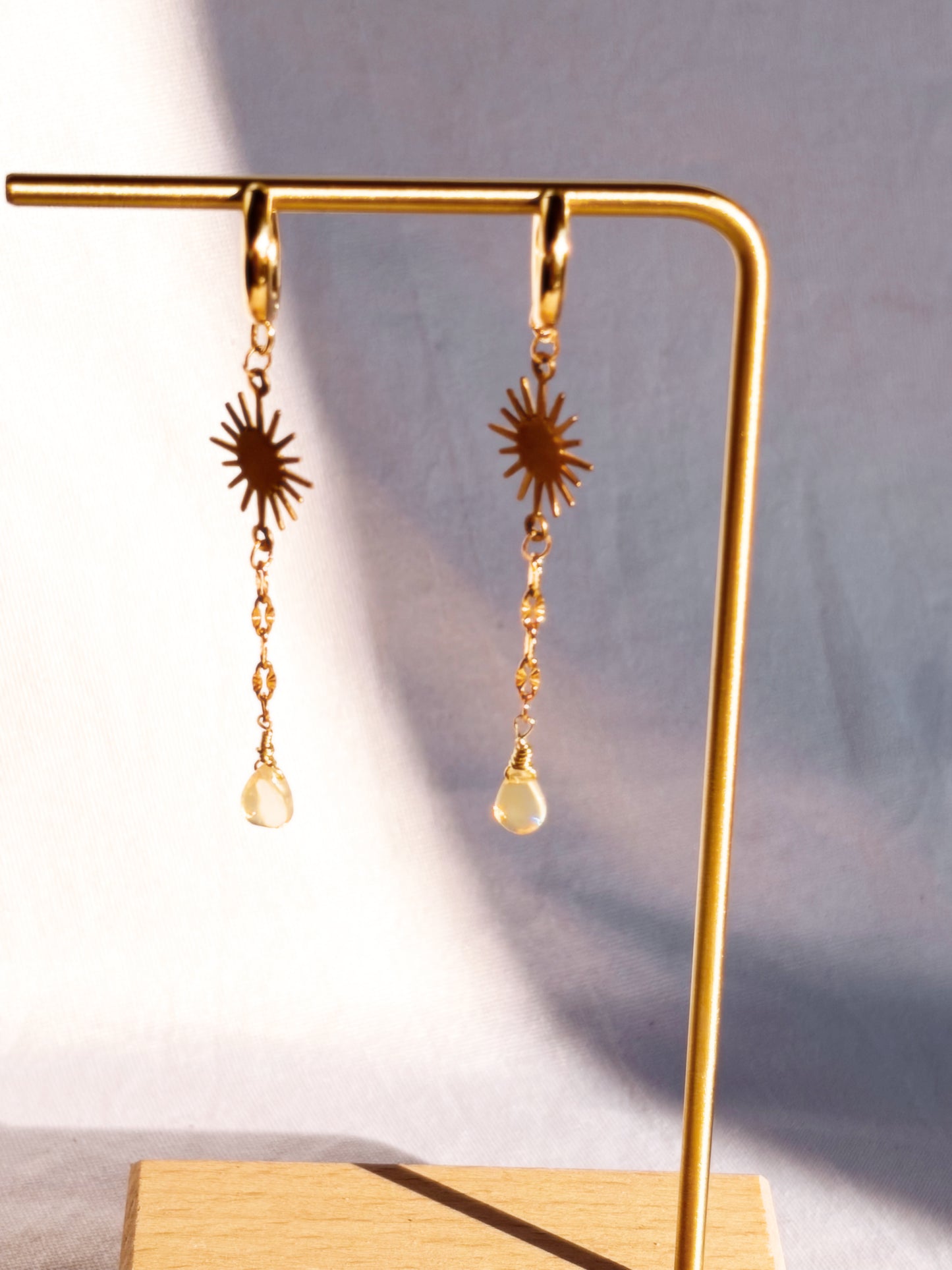 Gold Stainless Steel Opal earrings with Sun charms on a light background