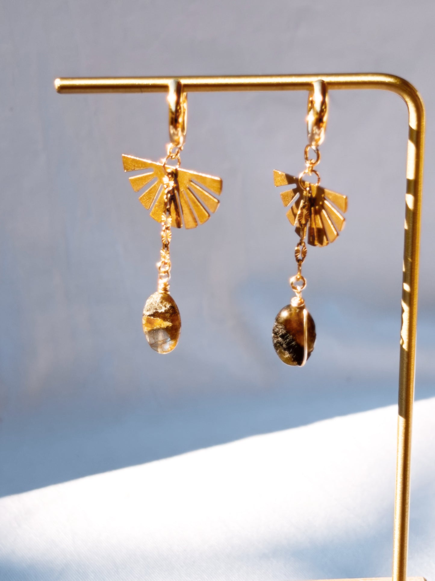 Labradorite Dangly Earrings with Brass and Stainless Steel hoops on a gold stand.