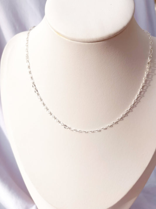 Close up of Stainless Steel Silver Lip chain Necklace on a white mannequin bust and background.