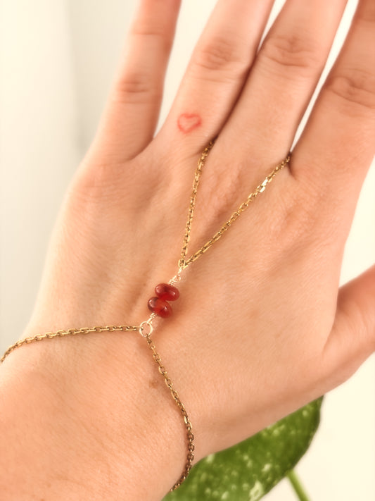 Gold Stainless Steel tarnish resistant handchain with Carnelian crystal beads on a person's hand