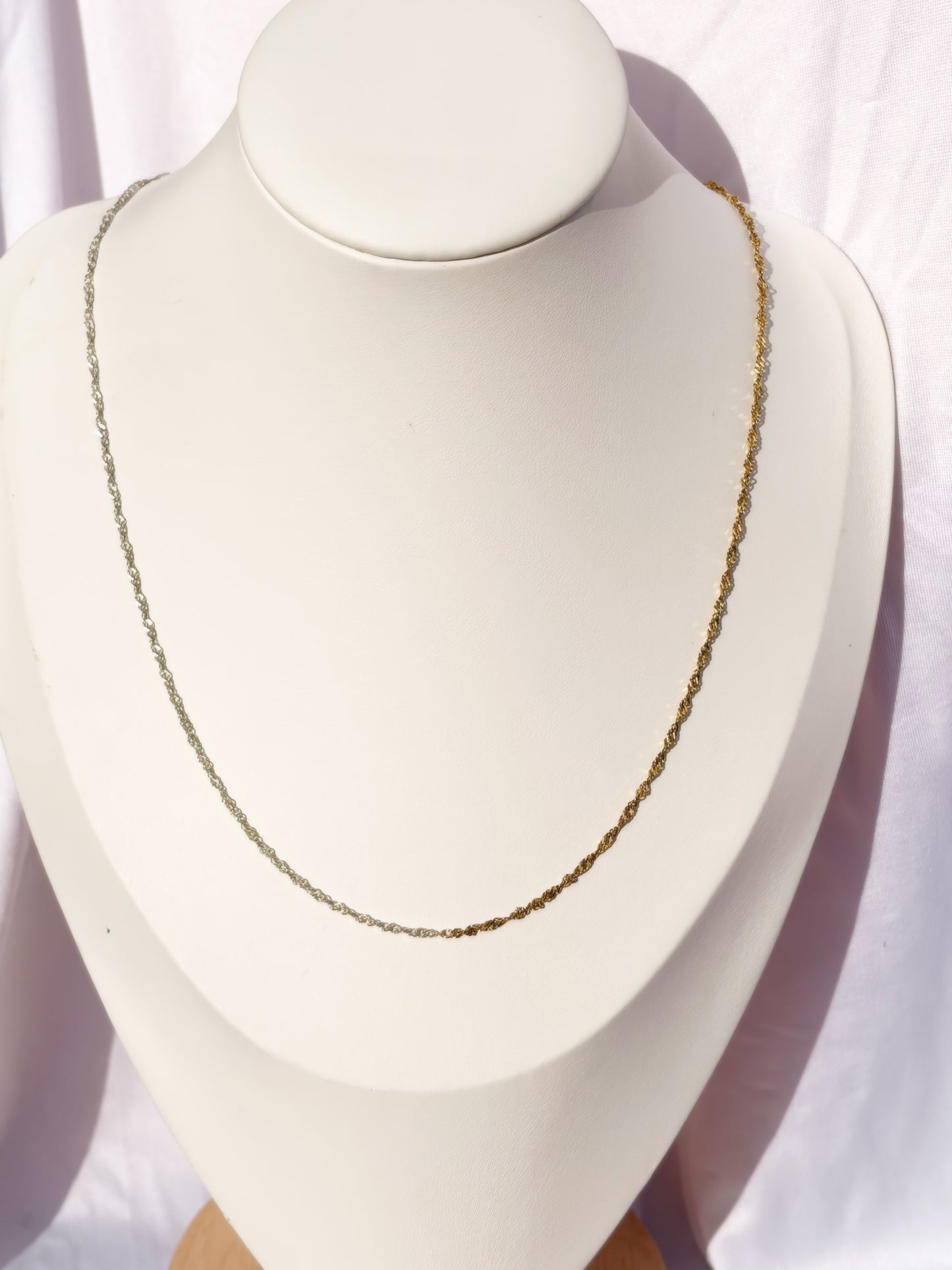 Figaro Gold and Silver Necklace on a bust on a white background.