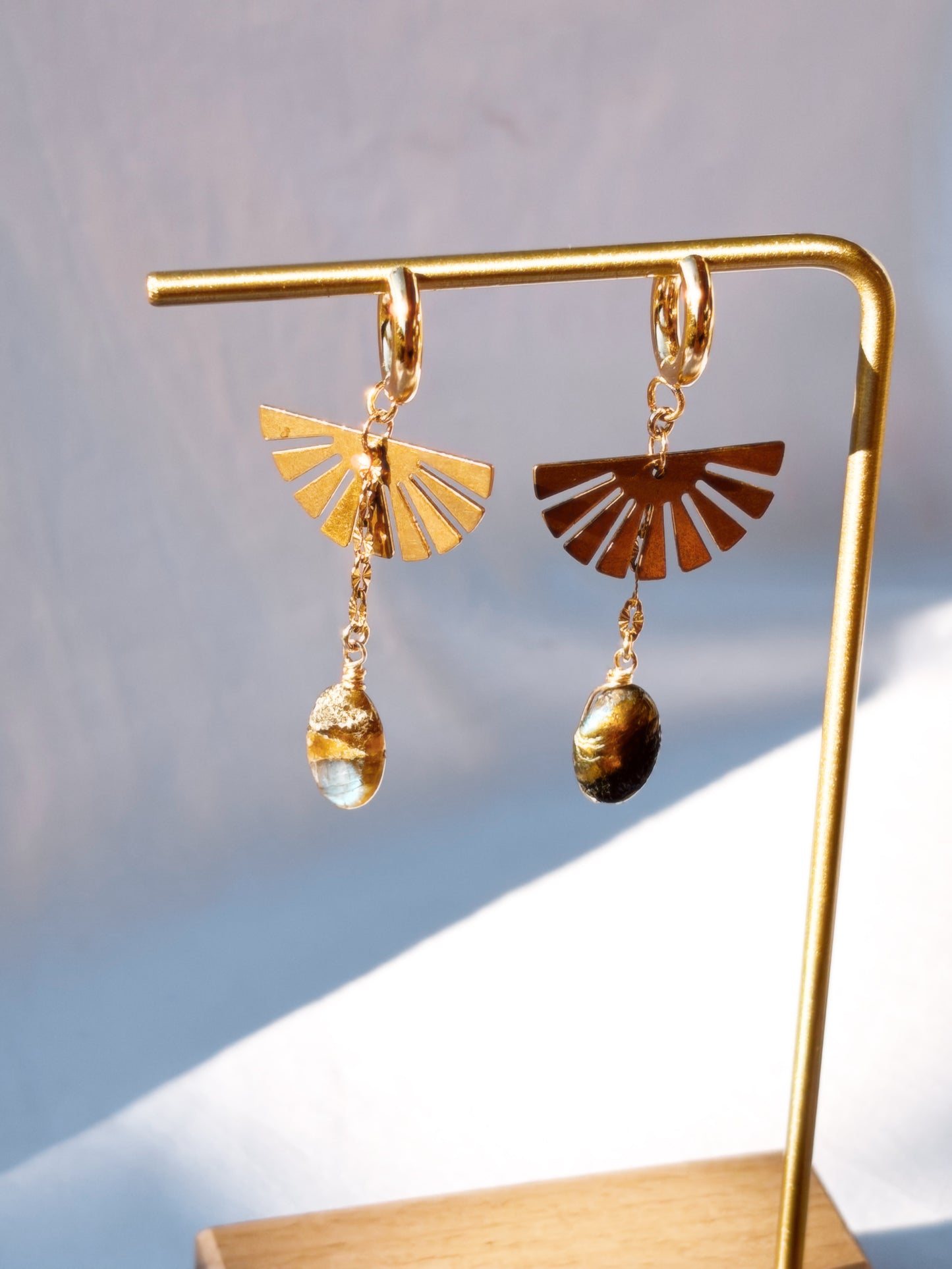 Labradorite Dangly Earrings with Brass and Stainless Steel hoops on a gold stand.