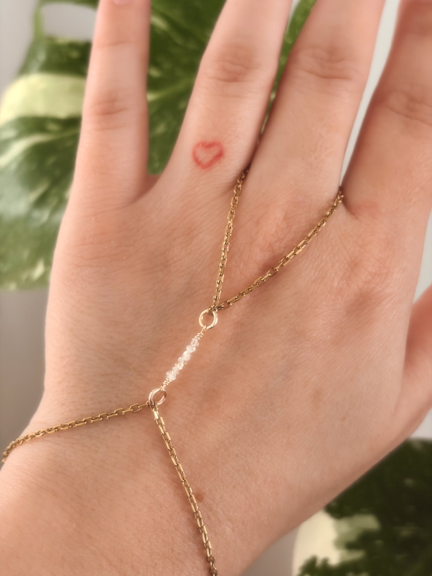 Gold Stainless Steel tarnish resistant handchain with Herkimer Diamond crystal beads on a person's hand.