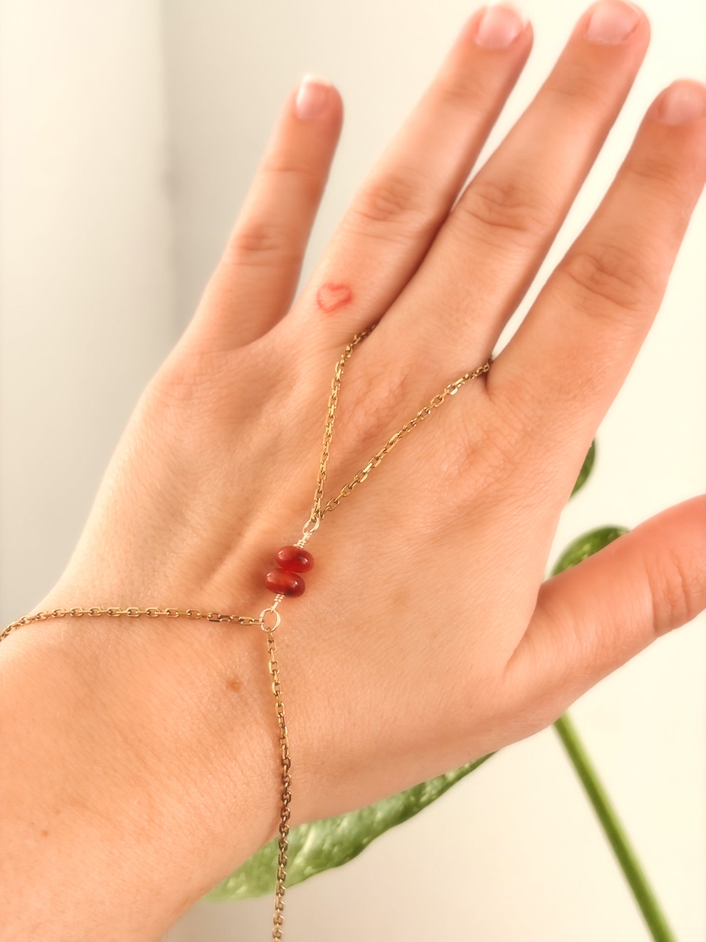 Gold Stainless Steel tarnish resistant handchain with Carnelian crystal beads on a person's hand