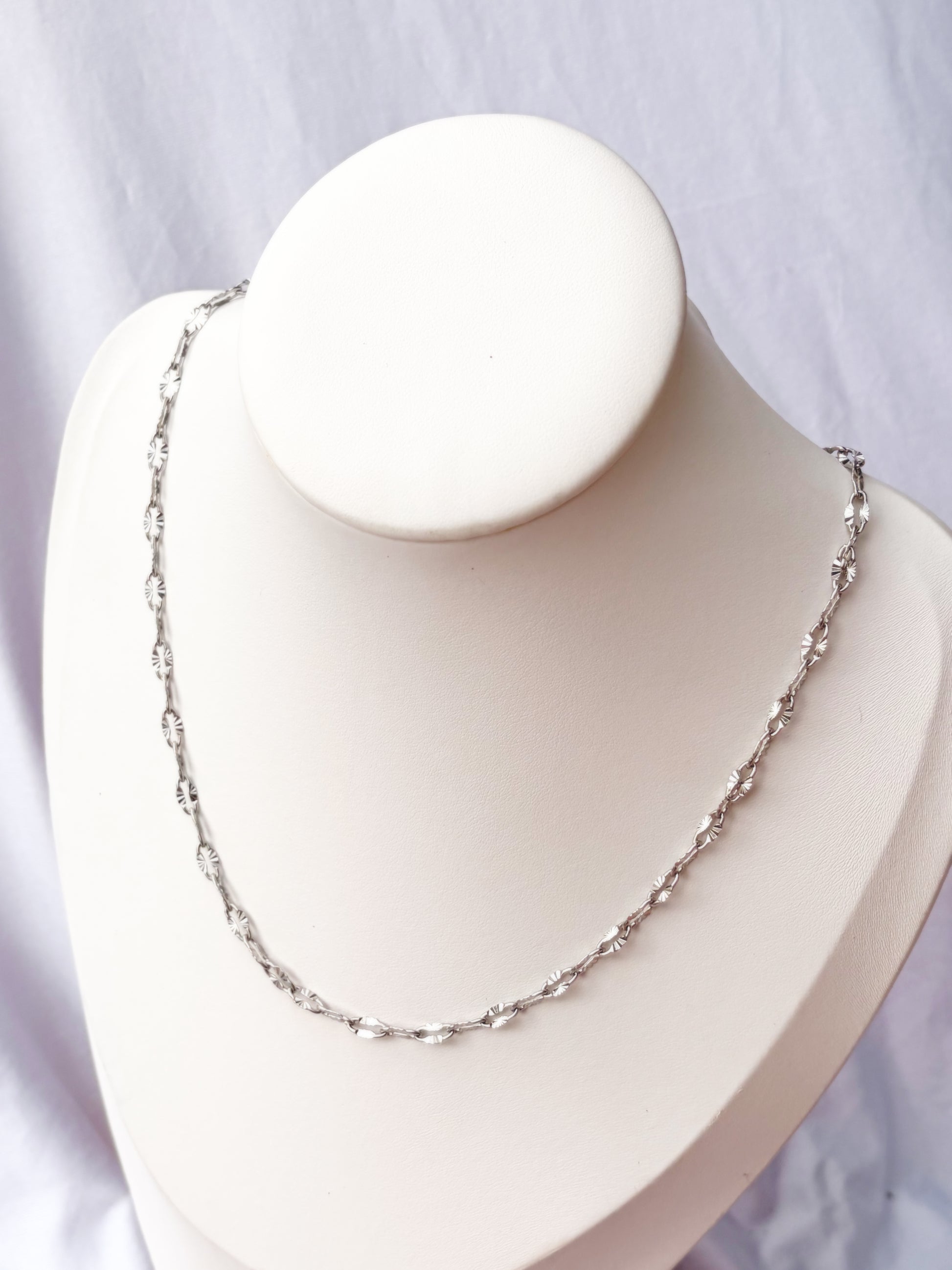 Silver Lip chain necklace on a white necklace holder with a white background
