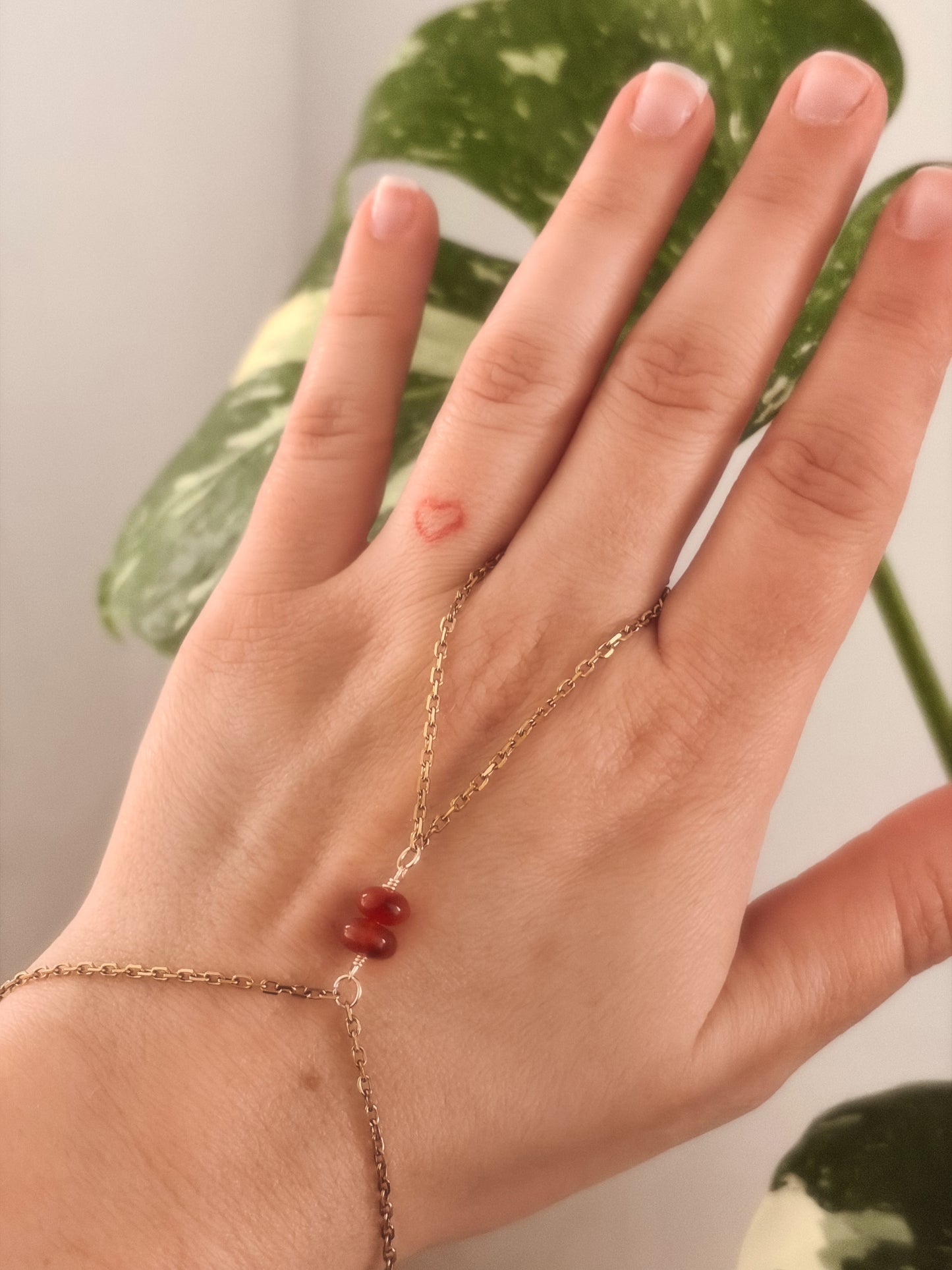 Gold Stainless Steel tarnish resistant handchain with Carnelian crystal beads on a person's hand