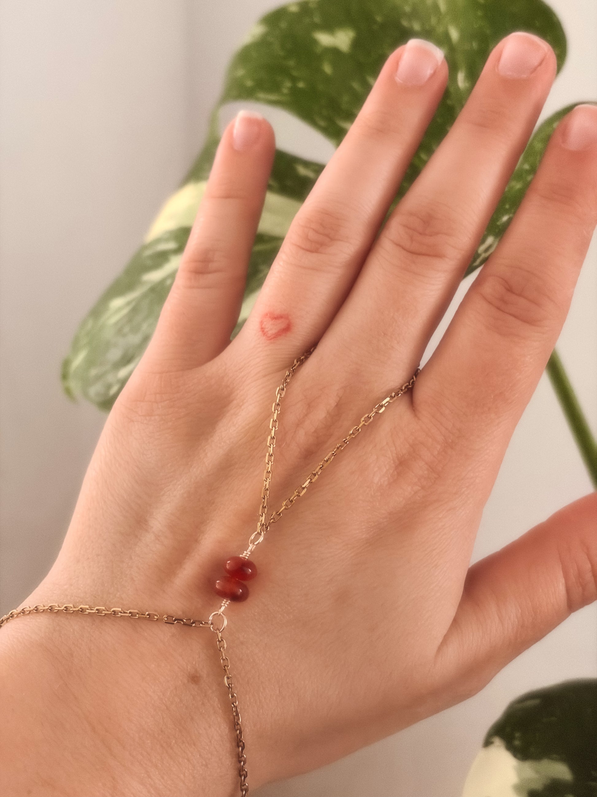 Gold Stainless Steel tarnish resistant handchain with Carnelian crystal beads on a person's hand