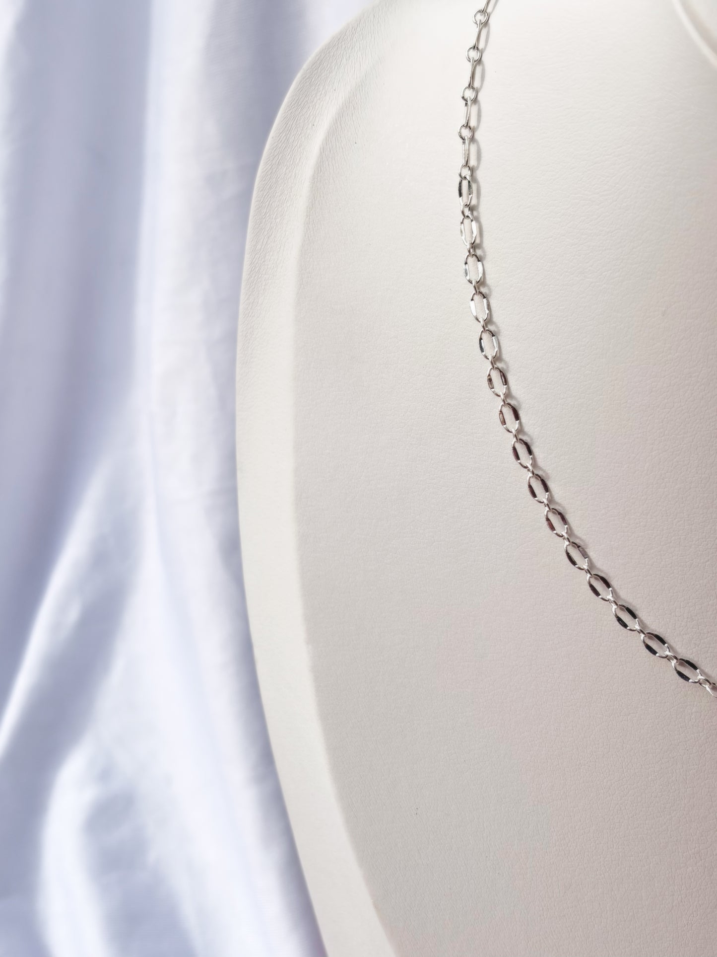 Close up of Stainless Steel Silver Lip chain Necklace on a white mannequin bust and background.