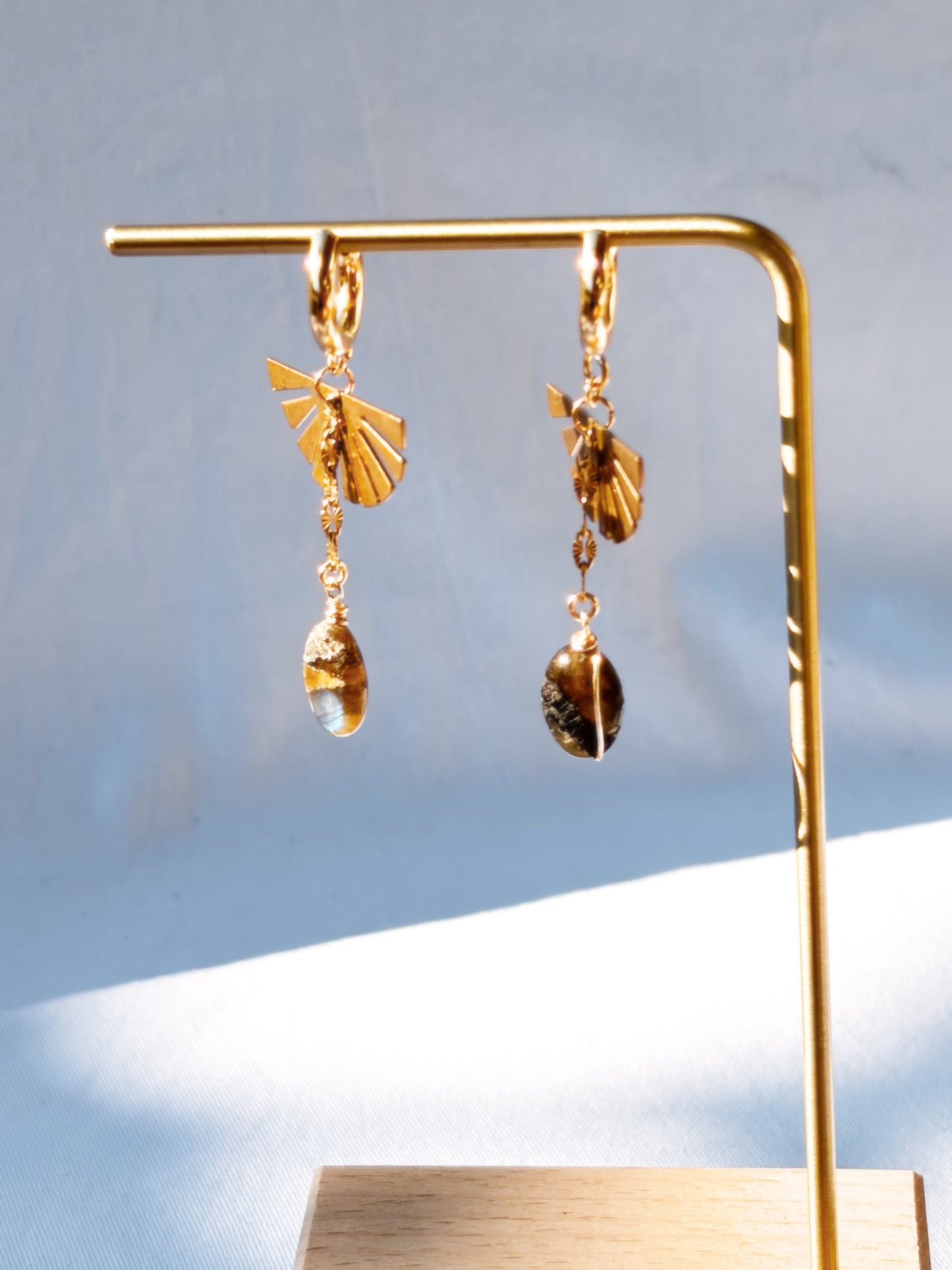 Labradorite Dangly Earrings with Brass and Stainless Steel hoops on a gold stand.