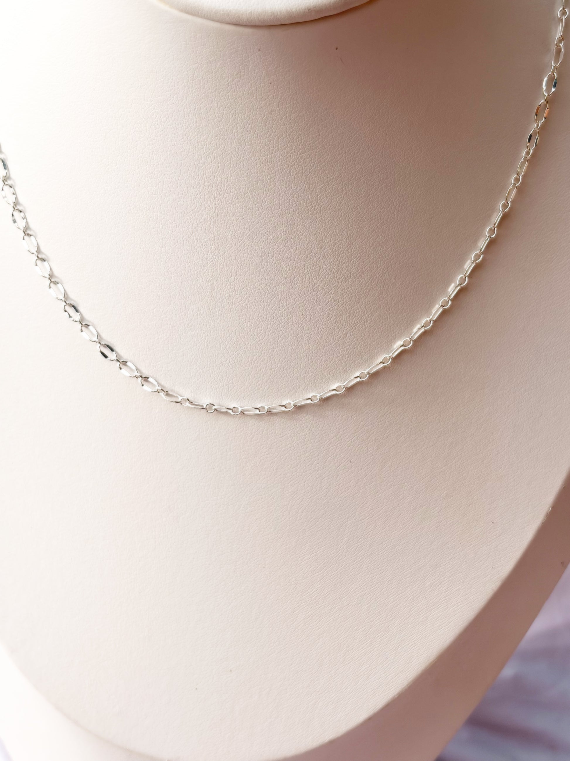 Close up of Stainless Steel Silver Lip chain Necklace on a white mannequin bust and background.