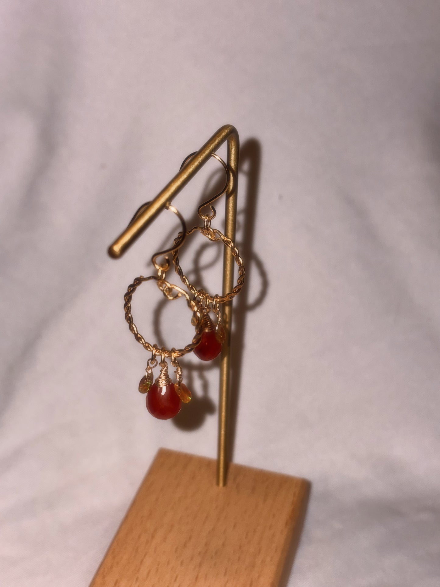 Gold brass and stainless steel hoop earrings with Carnelian and Ethiopian Opal beads on a white background.