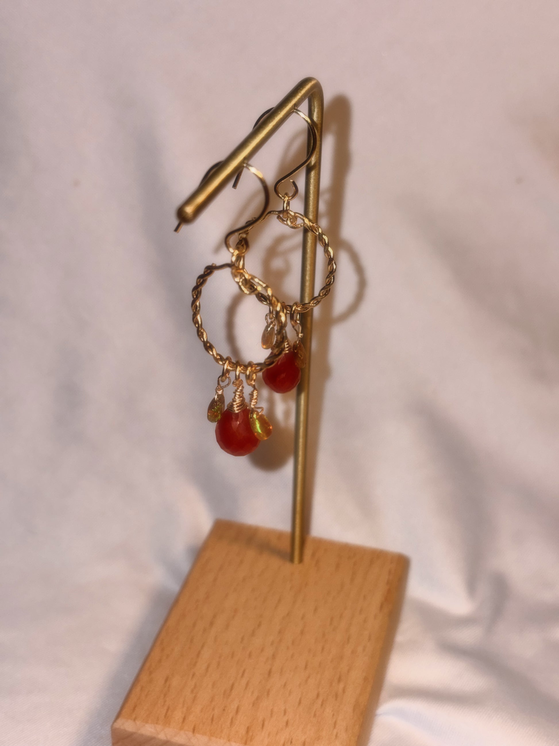 Gold brass and stainless steel hoop earrings with Carnelian and Ethiopian Opal beads on a white background.